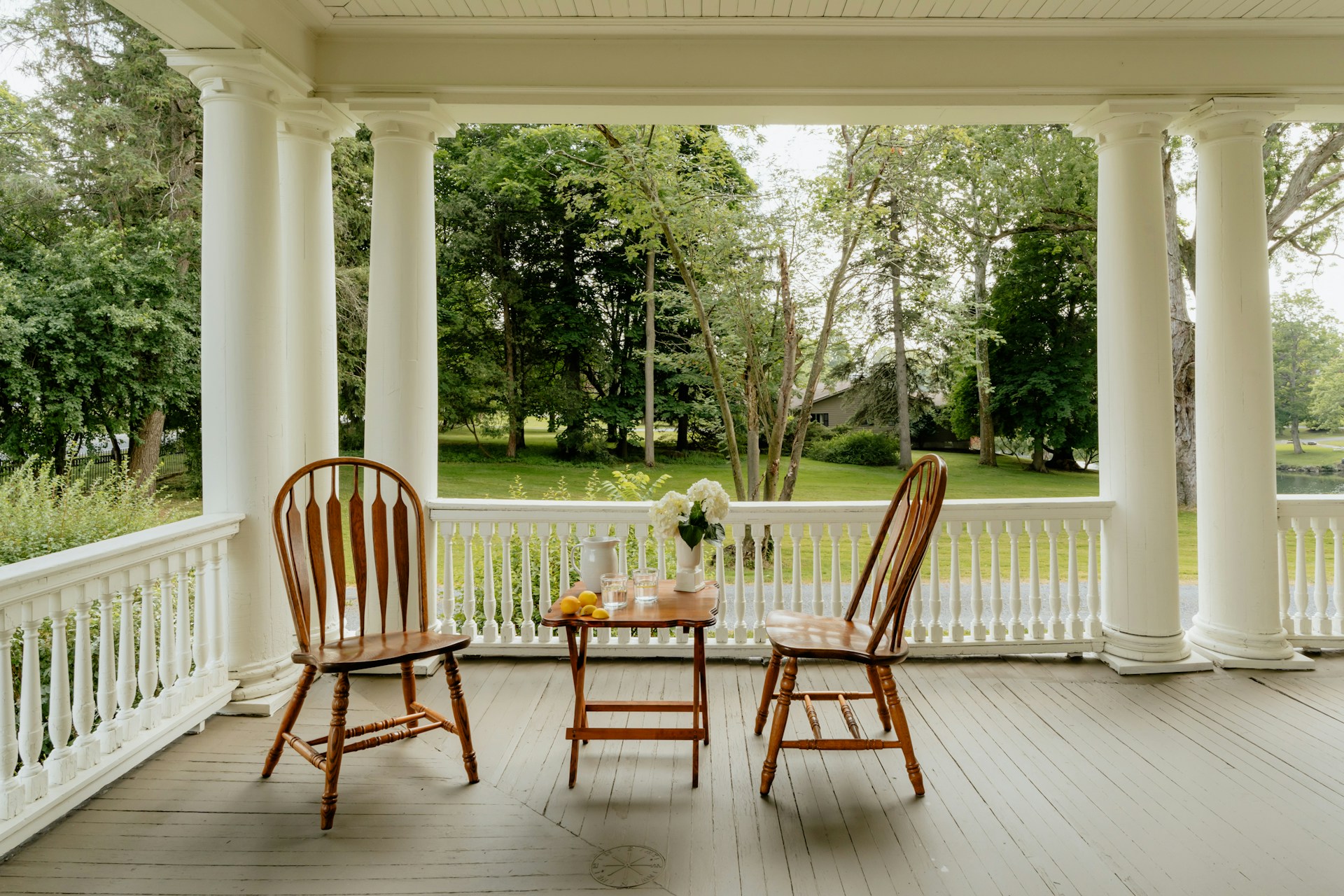 Two chairs and a small table waiting on a quiet porch